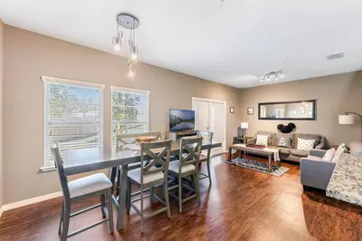 a dining room and living room with a table and chairs at Disney Dream Resort Amenities Pool *4BD/3BA* Close to Parks in Kissimmee