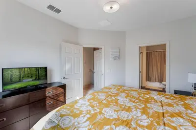 a bedroom with a bed and a flat screen tv at Disney Dream Resort Amenities Pool *4BD/3BA* Close to Parks in Kissimmee