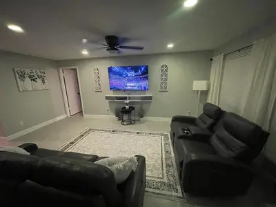 a living room with a couch and a flat screen tv at Family-Friendly DIsney Getaway in Kissimmee