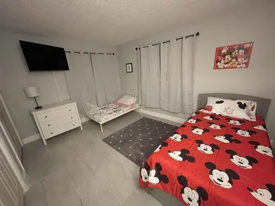 a bedroom with a red bed with mickey mouse pillows at Family-Friendly DIsney Getaway in Kissimmee