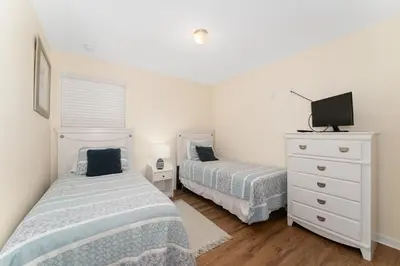 a bedroom with two beds and a dresser with a tv at Pool Townhouse near to Disney - Bella Vida Resort in Kissimmee