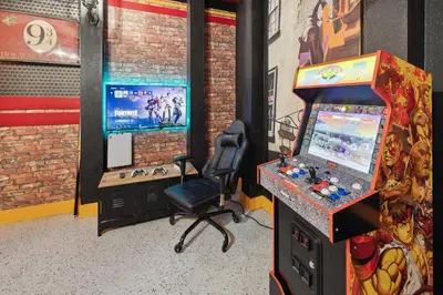 a video game room with a gaming machine and a chair at Modern 5 BDR Family Themed Home with Harry Potter Games Room and Free Pool Heat in Orlando