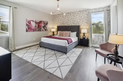 a bedroom with a large bed and two windows at Modern 5 BDR Family Themed Home with Harry Potter Games Room and Free Pool Heat in Orlando