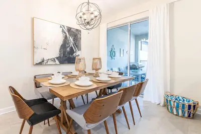 a dining room with a wooden table and chairs at Magic villa with themed bedrooms and private pool in Kissimmee