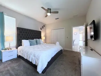 a bedroom with a large bed and a ceiling fan at 5 Bed 5 Bath South Facing Pool Home Storey Lake home in Kissimmee