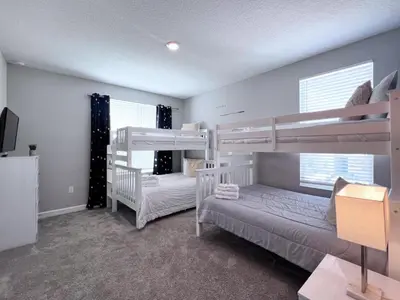 a bedroom with two bunk beds and two windows at 5 Bed 5 Bath South Facing Pool Home Storey Lake home in Kissimmee