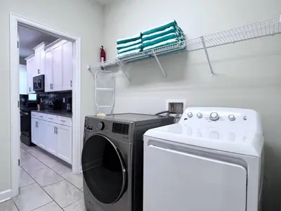 a kitchen with a washing machine and a dishwasher at 5 Bed 5 Bath South Facing Pool Home Storey Lake home in Kissimmee