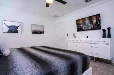 a white bedroom with a bed and a dresser at Gorgeous 4 Bedroom w Screened Pool Close to Disney 2653 in Kissimmee