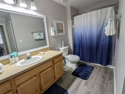 a bathroom with a sink and a toilet and a mirror at Nice & Cozy - Vacation Home in Kissimmee