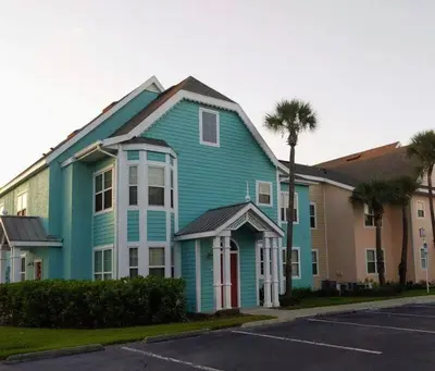 a blue house with a red door on a street at Nice & Cozy - Vacation Home in Kissimmee