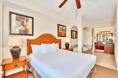 a bedroom with a large bed and a bathroom at 2BR Resort Suite - Fountain View Private Balcony in Kissimmee