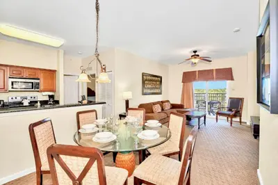 a kitchen and living room with a table and chairs at 2BR Resort Suite - Fountain View Private Balcony in Kissimmee