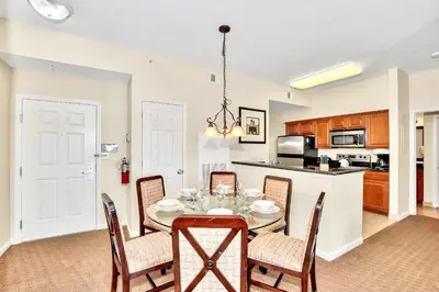 a kitchen and dining room with a table and chairs at 2BR Resort Suite - Fountain View Private Balcony in Kissimmee