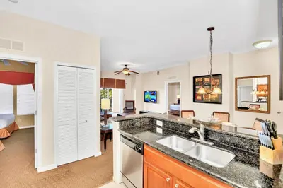 a kitchen with a sink and a living room at 2BR Resort Suite - Fountain View Private Balcony in Kissimmee