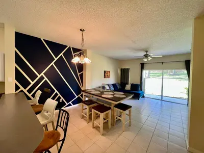 a living room with a table and a couch at Grand Deluxe 3BR Townhouse near Disney Parks in Kissimmee