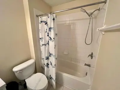 a bathroom with a white toilet and a shower at Grand Deluxe 3BR Townhouse near Disney Parks in Kissimmee