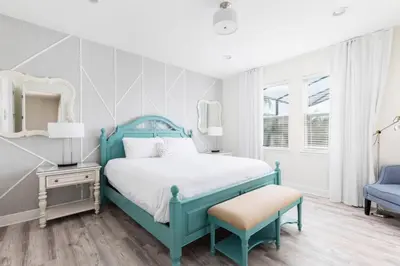 a bedroom with a blue bed and a chair at Fantabulous Disney Vacation House in Orlando