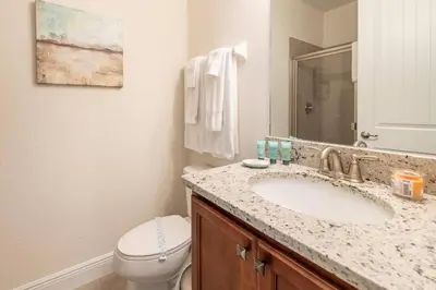 a bathroom with a sink and a toilet and a mirror at Fantabulous Disney Vacation House in Orlando