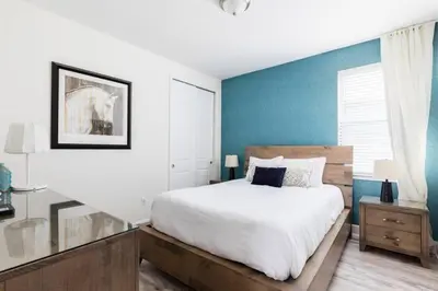 a bedroom with a large bed and a blue wall at Fantabulous Disney Vacation House in Orlando