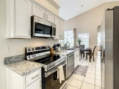 a kitchen with a stove and a microwave at Family pool home near Disney wBBQ grill in Orlando
