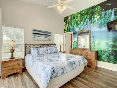 a bedroom with a bed and a painting on the wall at Family pool home near Disney wBBQ grill in Orlando