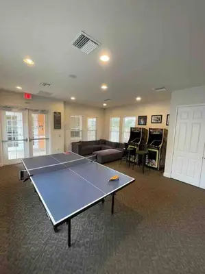 a ping pong table in a room with a couch at Like home, but better in Orlando