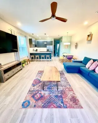 a living room with a blue couch and a table at Like home, but better in Orlando