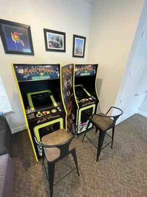 two video game machines and two chairs in a room at Like home, but better in Orlando