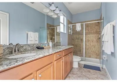 a bathroom with a sink and a shower and a toilet at Lakefront 5BR Resort Pool Home Near Disney World in Kissimmee
