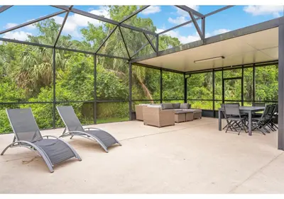 a glass house with a table and chairs at Lakefront 5BR Resort Pool Home Near Disney World in Kissimmee