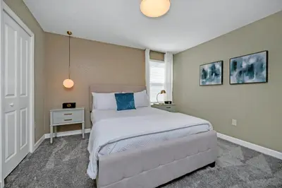 a bedroom with a large white bed with a blue pillow at 9 Bedrooms 5 Bathrooms Storey Lake 2854 Bd in Kissimmee