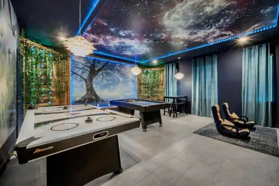 a game room with a table and a tree mural at 9 Bedrooms 5 Bathrooms Storey Lake 2854 Bd in Kissimmee