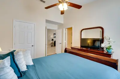 a bedroom with a blue bed and a mirror at Kissimmee Vacation Rental with Pool about 4 Mi to Disney in Kissimmee