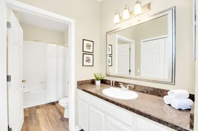 a bathroom with a sink and a mirror at 2BR Condo - Pool & Games - Near Disney in Orlando