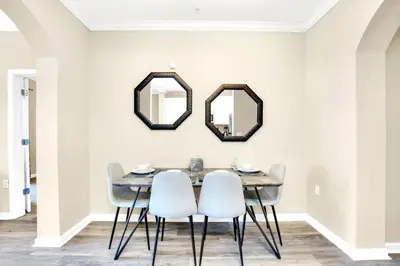 a dining room with a table and chairs and mirrors at 2BR Condo - Pool & Games - Near Disney in Orlando