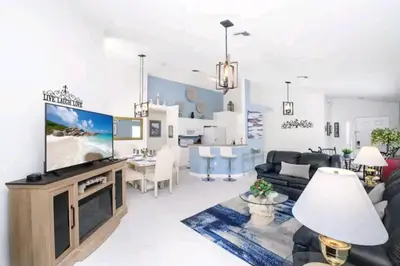 a living room with a large flat screen tv at Relaxing, Private Family Home At Lake Berkley Resort, South Facing Pool, Near Disney, SeaWorld in Kissimmee