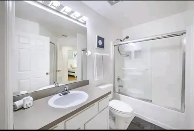 a white bathroom with a sink and a toilet at Relaxing, Private Family Home At Lake Berkley Resort, South Facing Pool, Near Disney, SeaWorld in Kissimmee