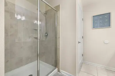 a shower with a glass door in a bathroom at Magic Condo 3BR at Storey Lake – 10 min to Disney in Kissimmee
