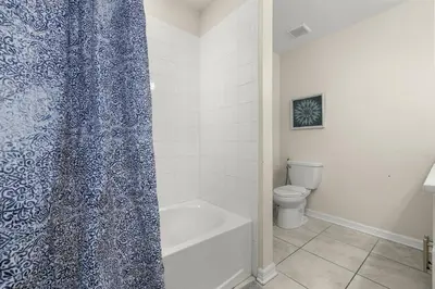 a bathroom with a toilet and a shower curtain at Magic Condo 3BR at Storey Lake – 10 min to Disney in Kissimmee