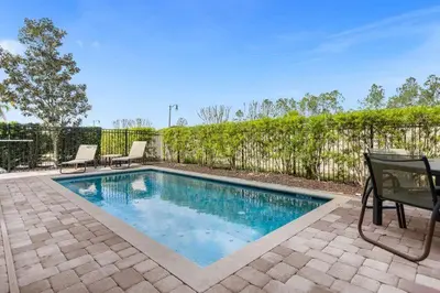 a swimming pool with two chairs and a fence at Multiple Family Homes - 23 Rooms PoolsSpas in Orlando