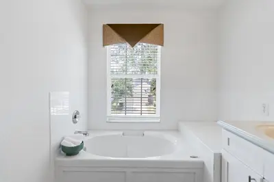 a white bathroom with a tub and a window at The Pink House at Windsor Hills in Orlando