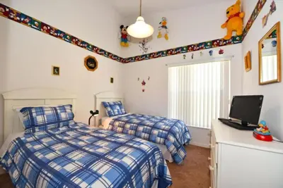 a bedroom with two beds and a tv at Rise & Shine! in Orlando