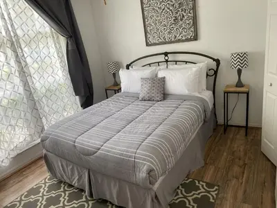 a bedroom with a bed with a gray and white comforter at Just Wanna Have Sun! in Orlando