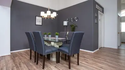a dining room with a glass table and blue chairs at Just Wanna Have Sun! in Orlando