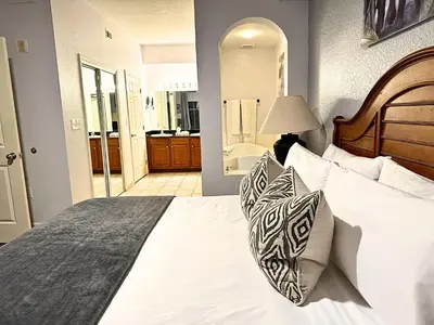 a bedroom with a large bed and a bathroom at Pirate Ship Resort Condo in Orlando