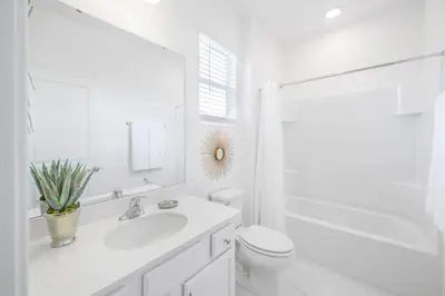 a white bathroom with a sink and a toilet at Near Disney - 12BR Home - Private Pool and Hot Tub in Kissimmee