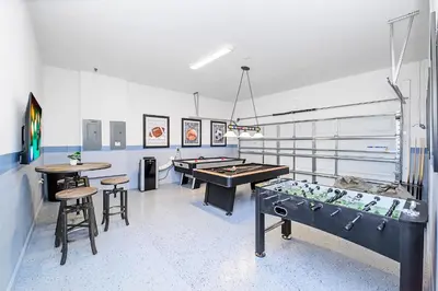 a room with a ping pong table and two tables at Near Disney - 12BR Home - Private Pool and Hot Tub in Kissimmee