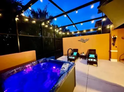 a backyard with a jacuzzi tub on a patio at AMAZING vacation house .Mins to Disney Regal oasks in Orlando
