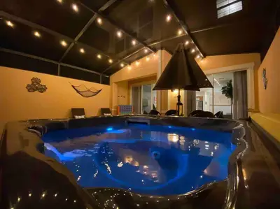 a large swimming pool in a living room with a blue tub at Find your Cozy home 8 minutes near Disney and Universal in Orlando
