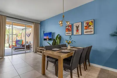 a dining room with blue walls and a table and chairs at Find your Cozy home 8 minutes near Disney and Universal in Orlando